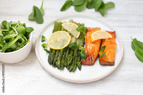 Baked salmon and asparagus with salad and lemon. Top view. 