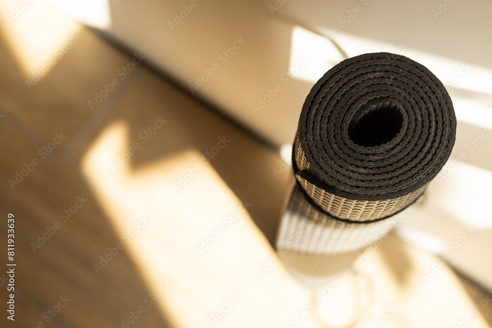 gray folded yoga mat against the wall, top view gray folded yoga mat against the wall, top view