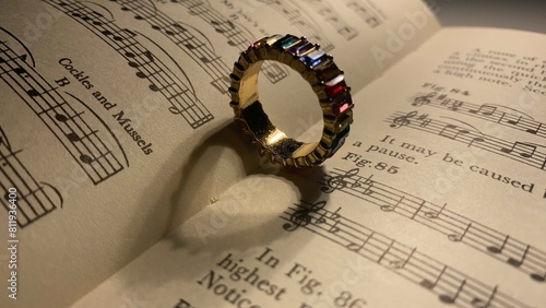 Ring made heart shadow on music book. Close Perspective
