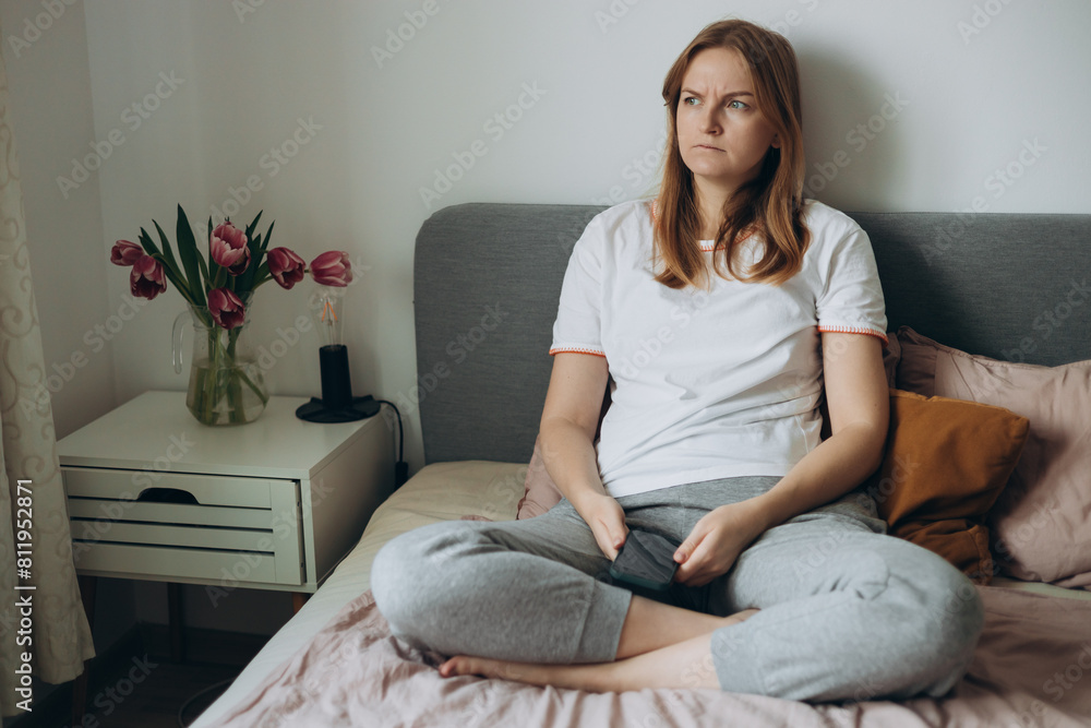 Upset young woman using phone and reading bad news, sad pensive girl sitting at home. Negative people emotion. Slow internet, access account trouble signing in, malfunction, need repair concept