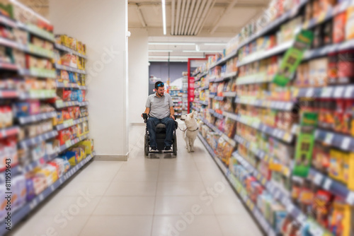 Man with disability and his service dog shopping in market store using electric wheelchair © 24K-Production