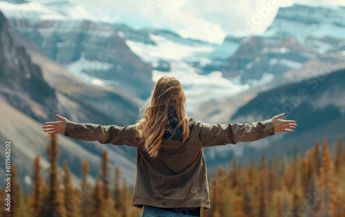Woman with arms outstretched  enjoying peace before mountain backdrop.