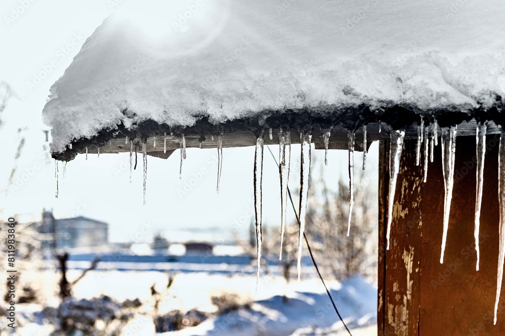 Icicles hang from the roof of the house in winter.