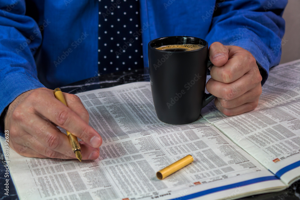 geschäftsmann studiert bei einer tasse kaffee die aktienkurse