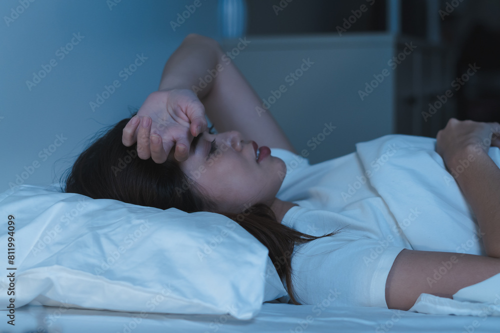 Close-up alarm Young Asian woman have insomnia on the bed Close-up alarm Young Asian woman have insomnia on the bed