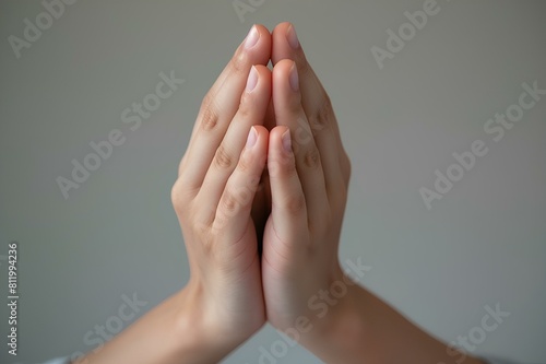 A close-up shot of folded hands emoji with light skin tone against a neutral background, conveying gratitude.