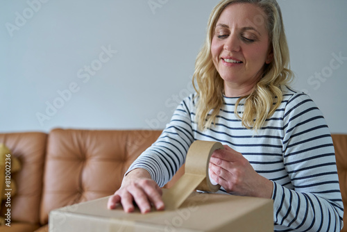 Woman Wrapping Parcel Using Green Environmentally Friendly Paper Or Plastic Free Sticky Tape