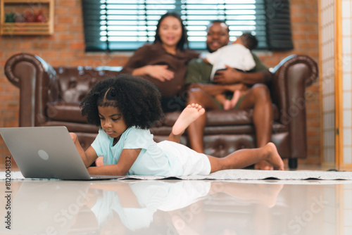 Happy African American Family at Home: Mother and Father Hug Their Young Daughter and Son, Sharing Love and Fun Together, Portraying Cheerful Moments of a Black American Household © chokniti