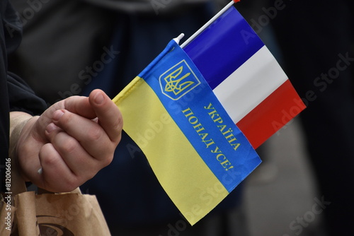 Ukrainian and French flags held by one hand