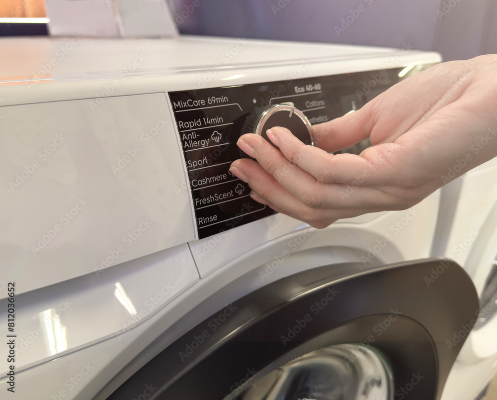 Household appliances in an electronics store. Upgraded washing machine close-up for cleaning clothes. Choosing a washing machine for your home. Household appliances in an electronics store. Upgraded washing machine close-up for cleaning clothes. Choosing a washing machine for your home.
