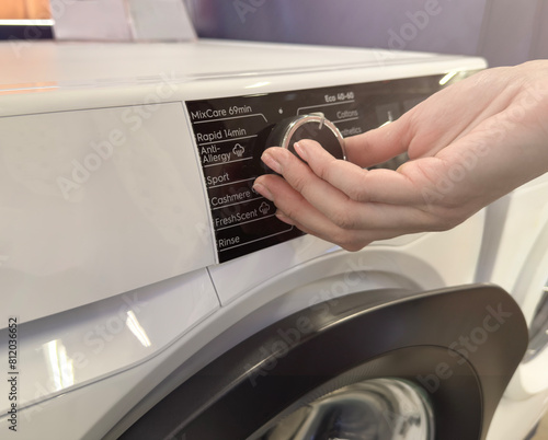 Household appliances in an electronics store. Upgraded washing machine close-up for cleaning clothes. Choosing a washing machine for your home.