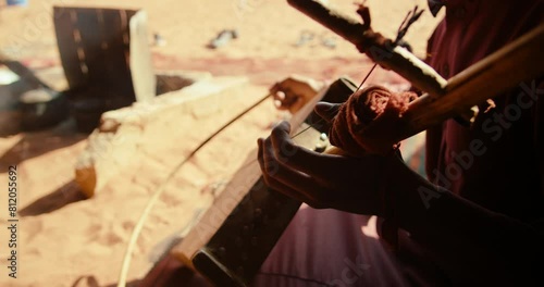 Authentic Arab Bedouin plays Music on Rebab String Instrument in Wadi Rum Desert in Jordan, Middle East. Local Traditional Culture and Hospitality. 4K closeup handheld shot photo