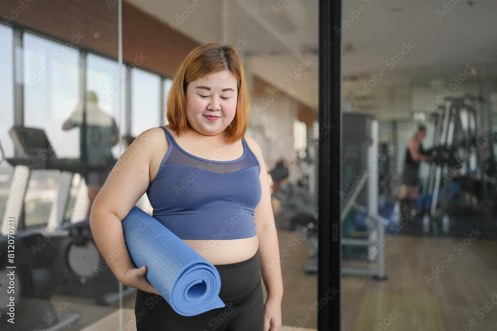 Obraz premium Obese asian woman diet holding yoga mat for training yoga exercising fitness workout and health concept. training working out at gym