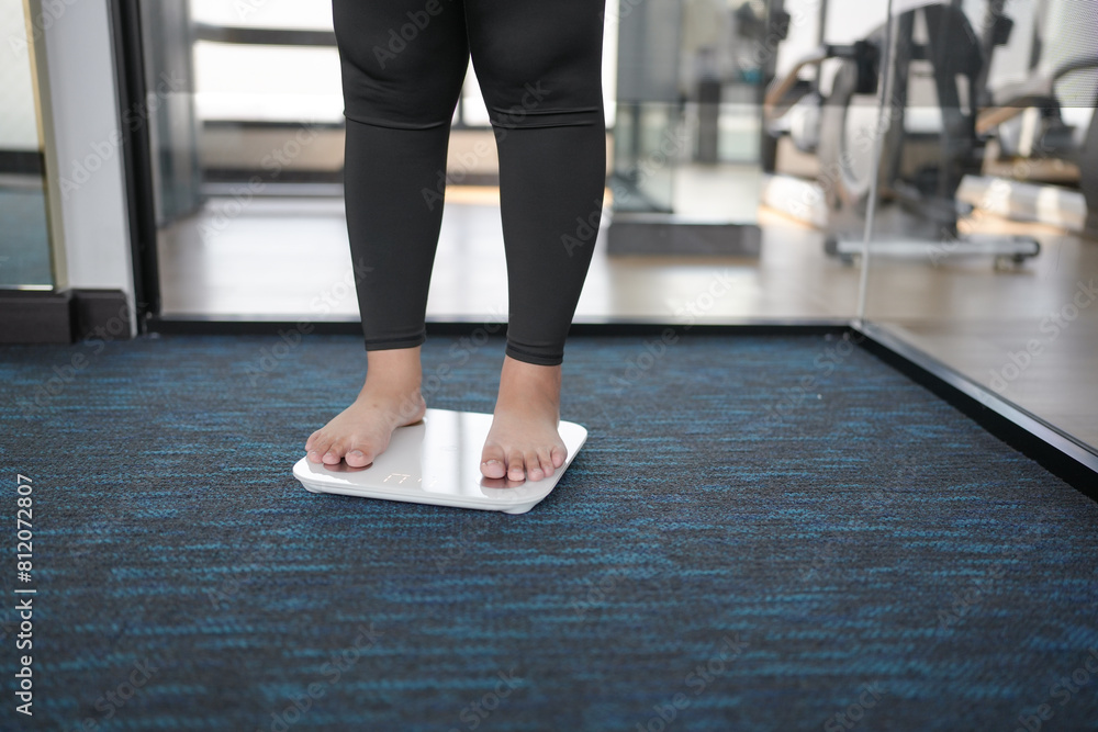 Fat diet and scale feet standing on electronic scales for weight control. Measurement instrument in kilogram for a diet control. Fat diet and scale feet standing on electronic scales for weight control. Measurement instrument in kilogram for a diet control.