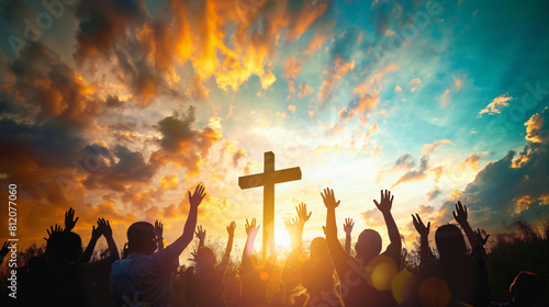 Group of crowd of Christians raise their hands in the air worshiping the cross. Religious concept of faith and prayer with bright sun set