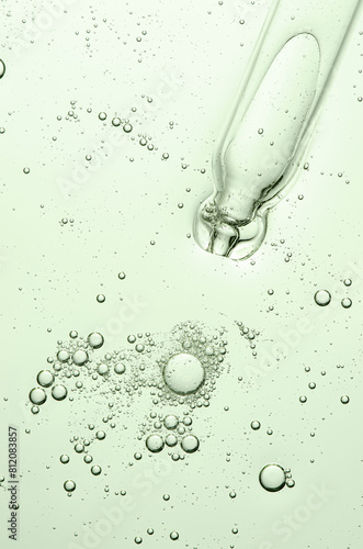 Green texture of a cosmetic serum with a pipette closeup. Macrophotography