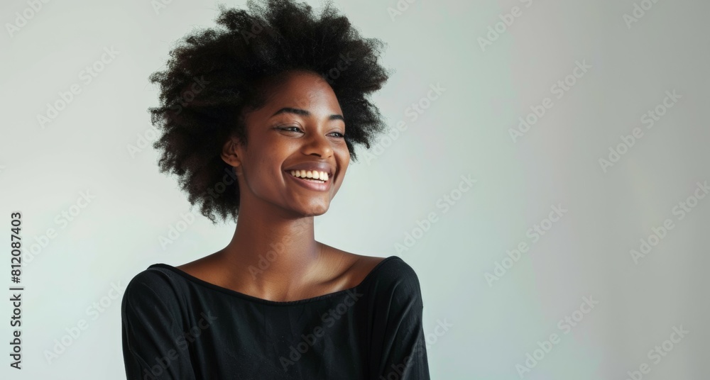 A woman with curly hair is smiling and looking at the camera A woman with curly hair is smiling and looking at the camera