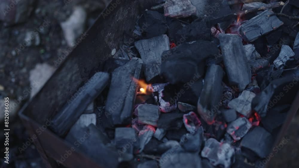 Slow motion shot of charcoal in brazier, preparation for bbq Slow motion shot of charcoal in brazier, preparation for bbq