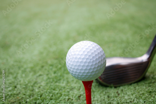 Golf ball set on a red golf stand on a green background.