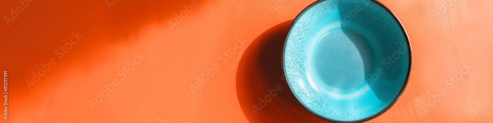 Striking Teal Ceramic Bowl Against a Vibrant Orange Background Striking Teal Ceramic Bowl Against a Vibrant Orange Background