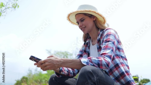 Female tourist holding a smartphone sits and admires the beautiful sea view. Tourism concept. hiking, traveler