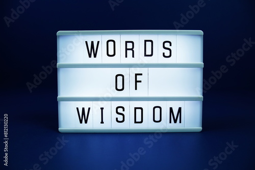 Words of wisdom letterboard text on LED Lightbox on blue background