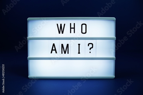 Who am I letterboard text on LED Lightbox on blue background photo