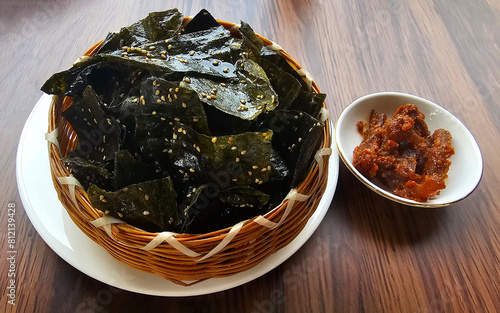 Experience the unique flavors of Luang Prabang food with Kai Paen Juen, fried rock algae chips, perfectly paired with traditional jeobong sauce, served in a woven basket photo