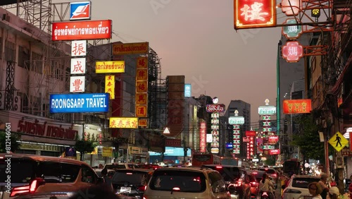 Bustling street scene at dusk in Bangkok's Chinatown with illuminated signs and heavy traffic. Bangkok Thailand. 5.01.2024