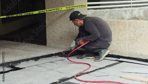 Installation of roll roofing waterproofing propane blowtorch during construction photo