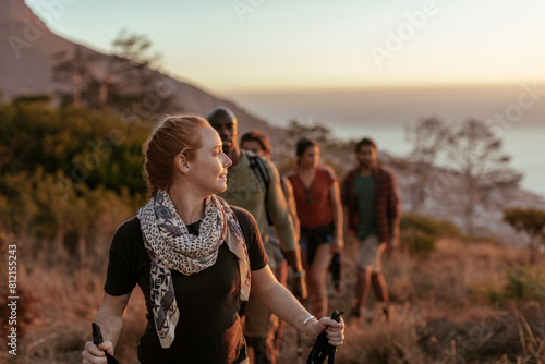 Group of friends hiking at sunset in scenic mountainous landscape photo
