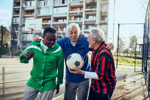 Senior friends discussing soccer tactics at a community sports field photo