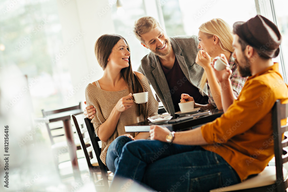 Group of friends enjoying coffee and conversation at cafe Group of friends enjoying coffee and conversation at cafe