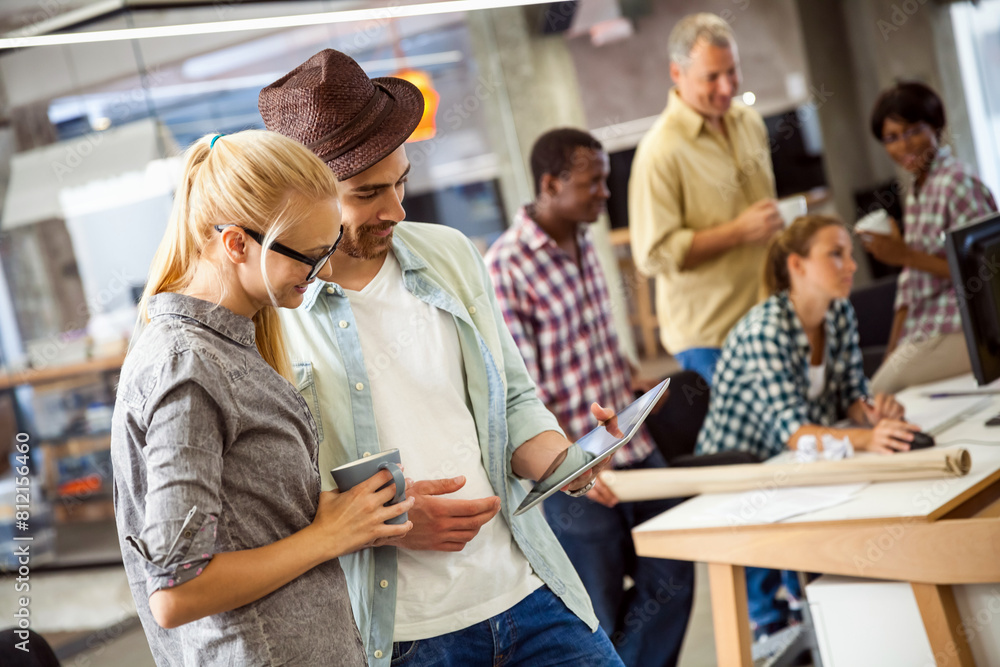 Two diverse young office workers using tablet together Two diverse young office workers using tablet together