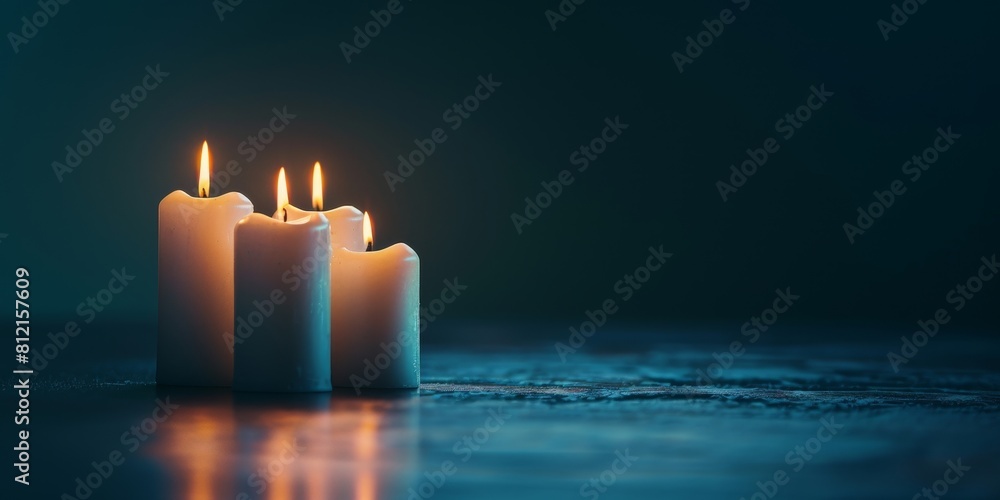Four white candles are burning on a dark blue background Four white candles are burning on a dark blue background