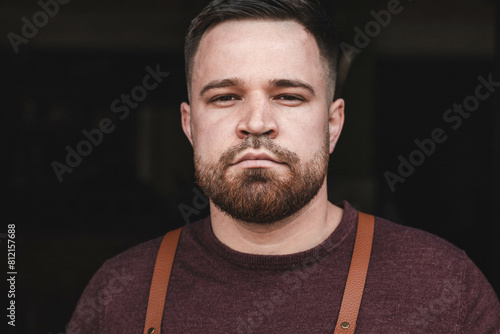 Close-up portrait of a handsome guy with leather suspenders standing