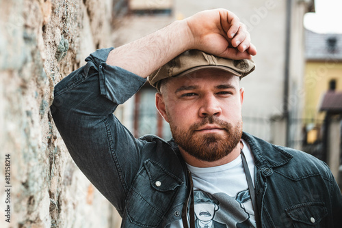 Portrait of a handsome guy with ivy hat standing, looking at camera