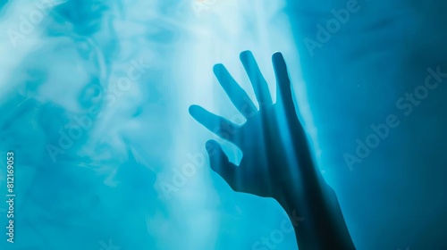 blurred human hand silhouette out of focus on blue background abstract photo