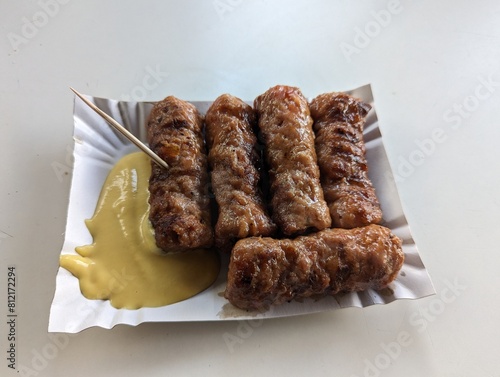 Obraz na płótnie Mici cu mustar and a toothpick on a paper plate. Traditional romanian fast food. w salonie