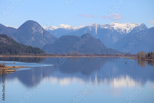 Snow-capped mountains reflected in surface of tranquil river