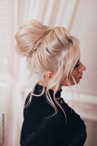 
Young blonde woman with makeup and fashion hairstyle in hairdressing salon
