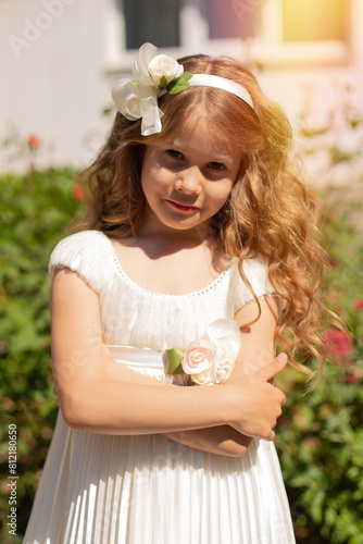 
Young little girl in beautiful dress walking in summer rose garden
