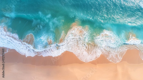 Beautiful aerial perspective of ocean waves lapping against a sandy beach, capturing the essence of summer vacation settings