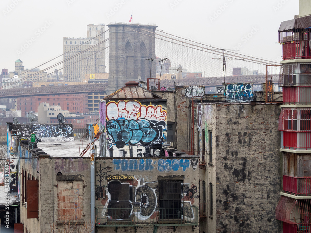 Brooklyn Bridge seen behind graffitied buildings