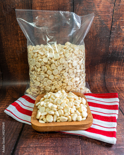 Bag filled with Peruvian corn kernels. Rustic wooden bottom. Vertical image for social networks.