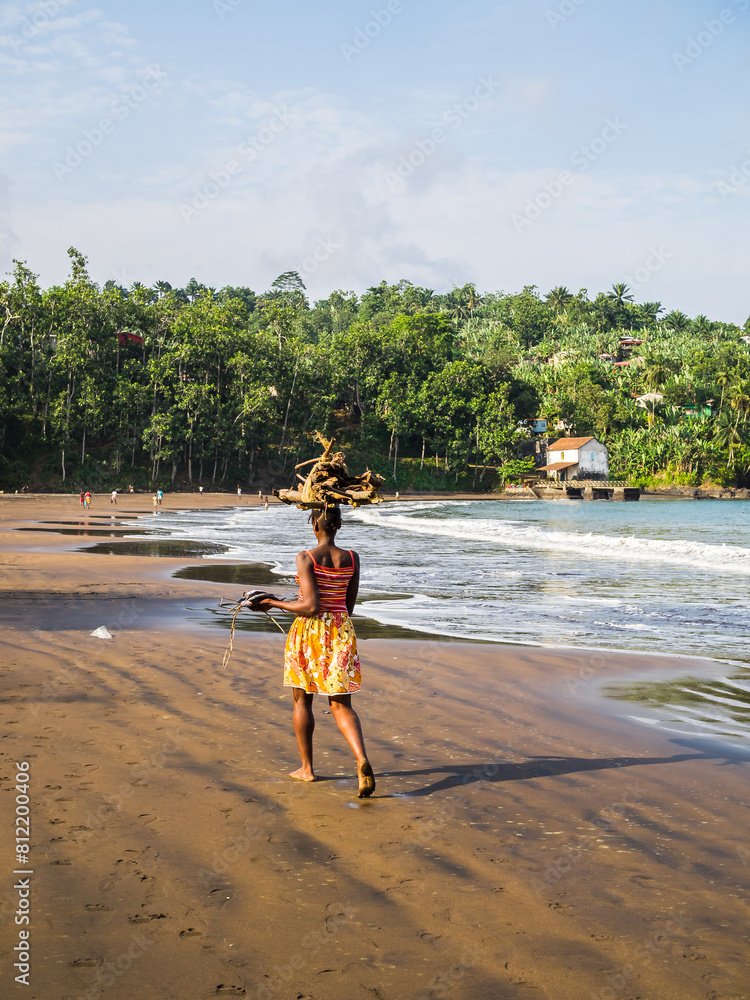 Using the beach as a road and carrying wood for fire on the head