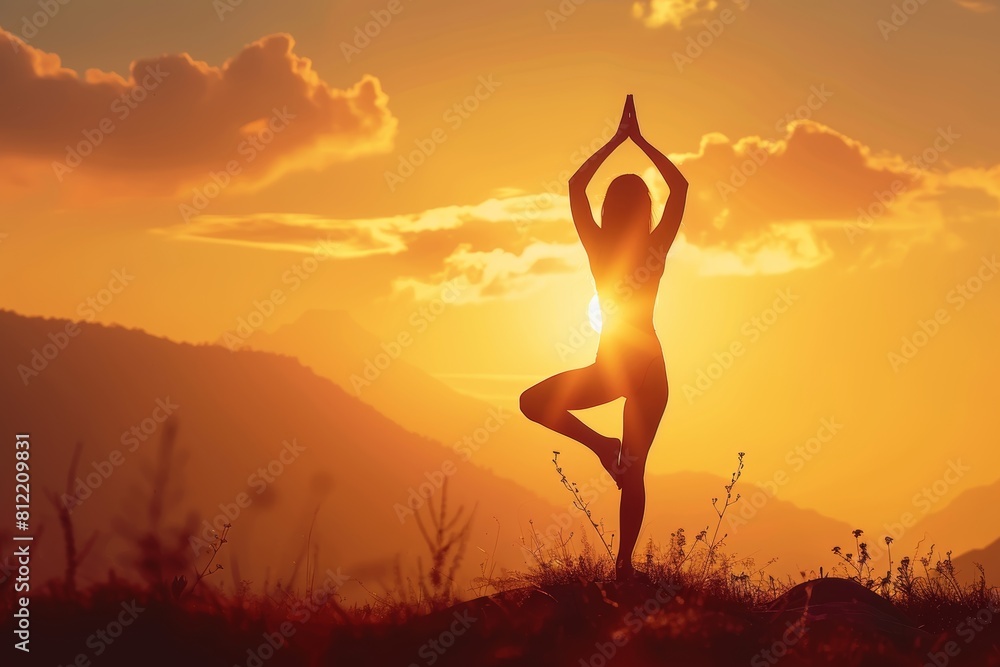 Female yoga enthusiast holds tree pose at sunset in tranquil field for mindful practice Female yoga enthusiast holds tree pose at sunset in tranquil field for mindful practice