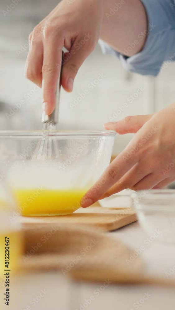 Vertical monitor. A woman with a belly beats eggs with a whisk. Steady camera movement of the expectant mother whipping eggs to bake pancakes, showing a caring attitude towards pregnancy Vertical monitor. A woman with a belly beats eggs with a whisk. Steady camera movement of the expectant mother whipping eggs to bake pancakes, showing a caring attitude towards pregnancy