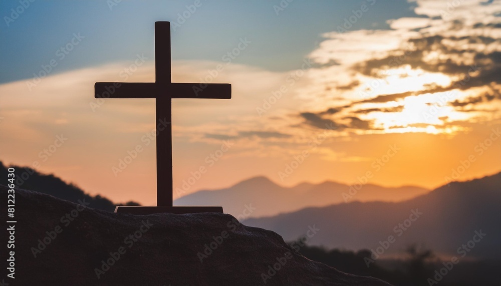 silhouette of crucifix cross on mountain at sunset sky background