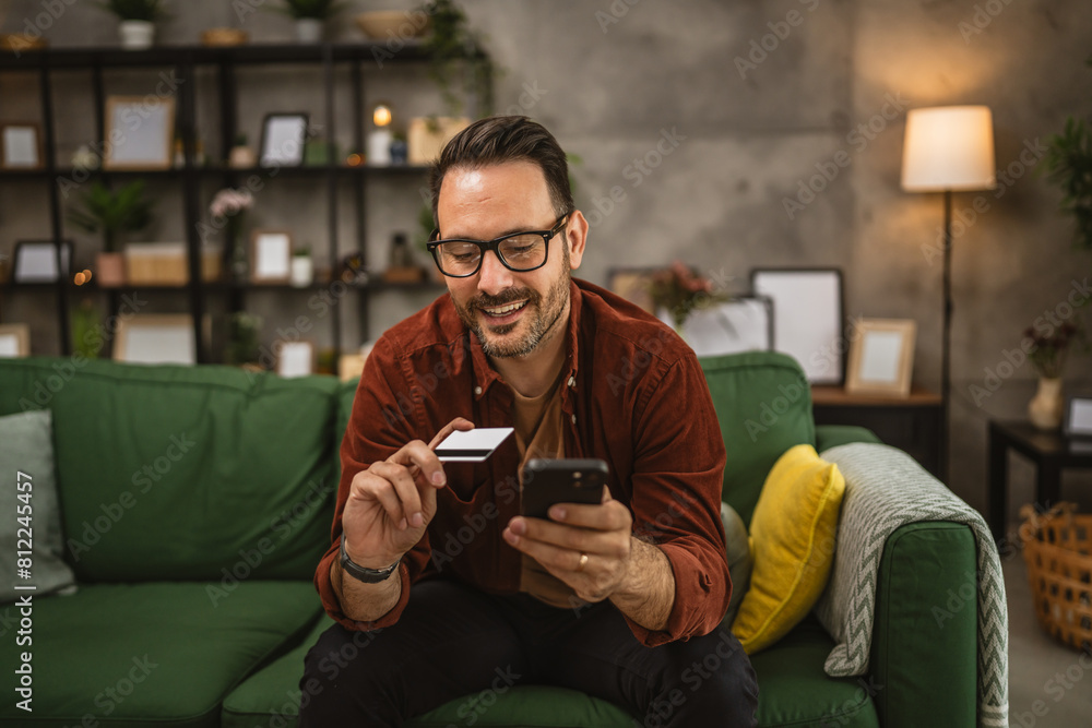 Portrait of adult man shop online with cellphone and hold credit card Portrait of adult man shop online with cellphone and hold credit card
